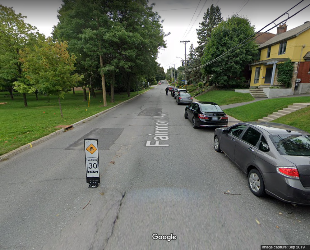 Screenshot taken from Google Streetview shows one flexible plastic bollard on Fairmont avenue, places in the middle of the street, with onstreet parking to the right. Fairmont has no sidewalks on the side buffering the park.
