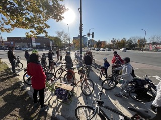 Group of people on bikes gathered at Montreal Road and Vanier Parkway before riding the newly opened bicycle lanes.