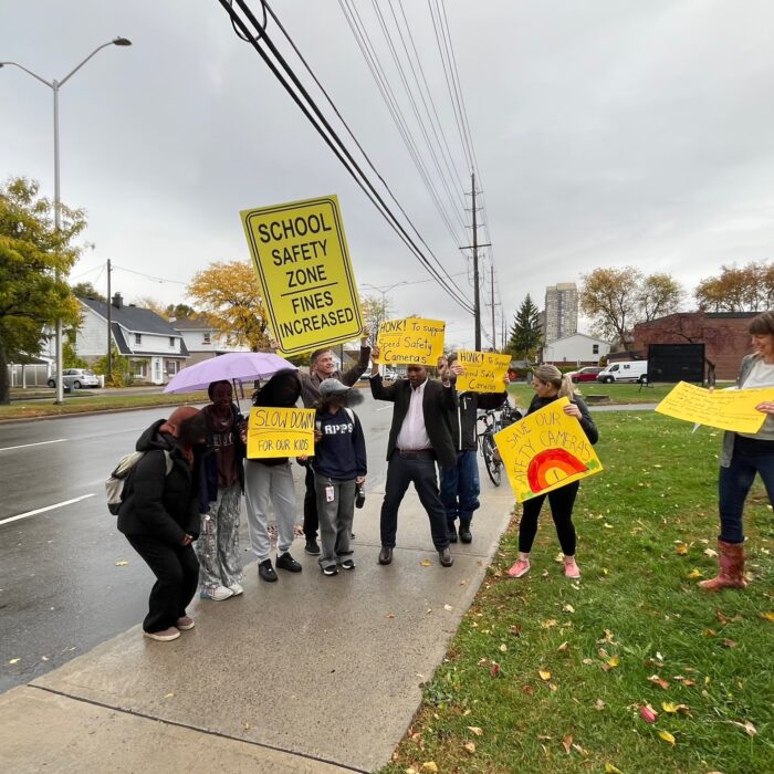 Students, city councillors and parents demonstrating against the removal of speed safety cameras in front of Queen Elizabeth School.