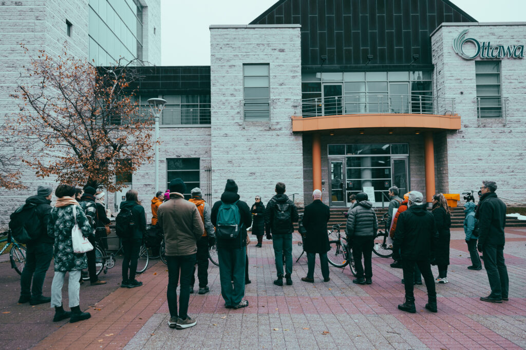 Participants at a rally against Bill 60 provision regarding bike lanes listen to a speaker.