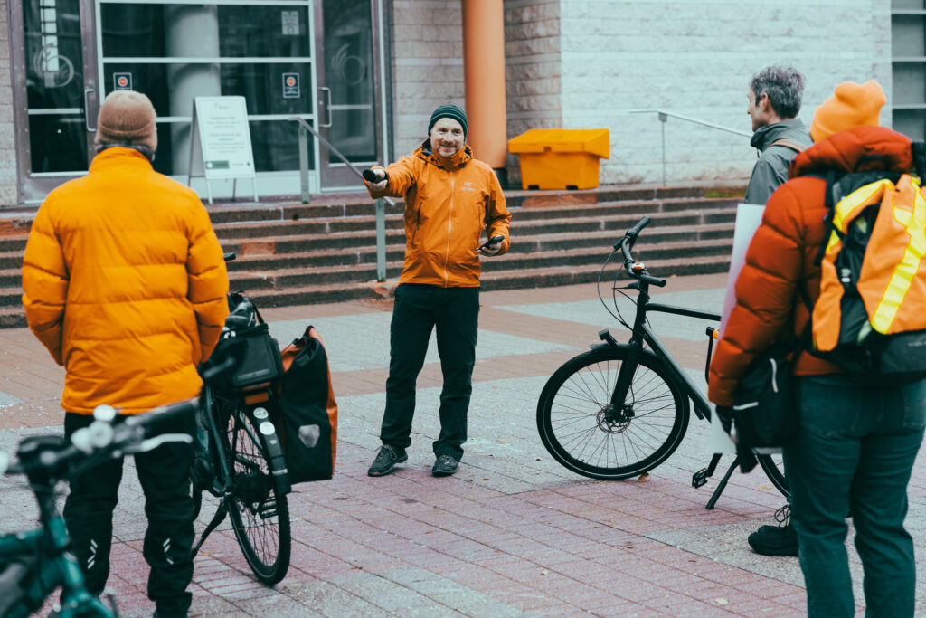 Chris Hircock from School Streets Ottawa addressing the Bill 60 rally. He’s leading a chant. People are seen in the foreground.