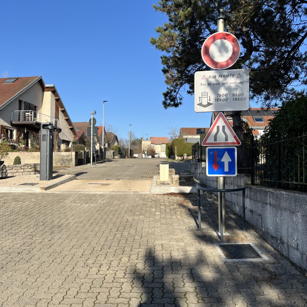 A chicane on a neighbourhood street with an automated retractable bollard in the middle. Bollard goes up at rush hour to prevent through traffic.